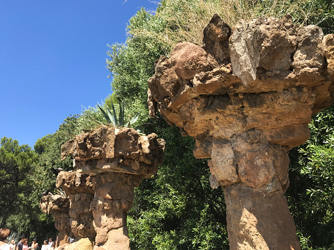 07/29/2019 -Barcelona, Catalonia, Spain: view of Colonnaded roadway, Tourist in Colonnaded footpath under the roadway viaductby Antoni Gaudi in Park Guell during summer time