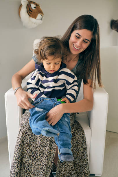 istock Happy mother putting jeans on son 1889480292