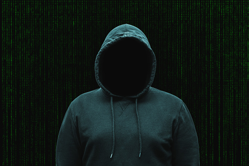 Mysterious faceless hooded anonymous computer hacker, silhouette of cybercriminal, terrorist.