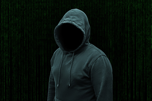 Mysterious faceless hooded anonymous computer hacker, silhouette of cybercriminal, terrorist