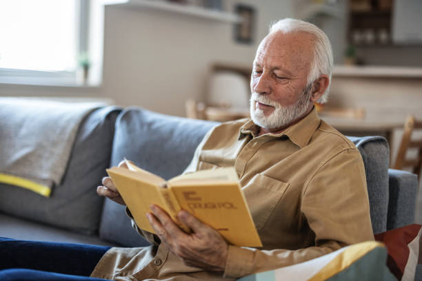 istock Senior men enjoying time at home by reading his favorite book. 1889507793
