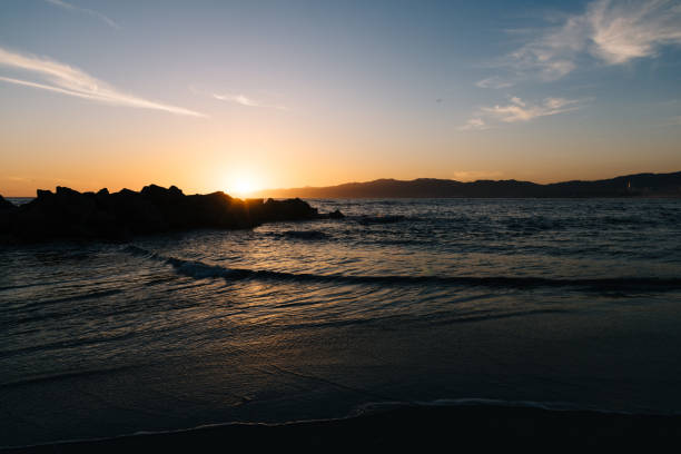 istock Sunset behind the rocks on the beach 1889524461