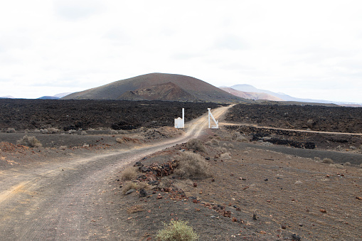 Dirt road in a volcanic landscape in Los Ajaches National Park near Papgayo. Playa Blanca, Lanzarote, Spain