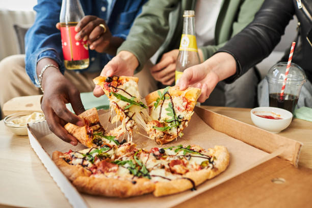 istock Friends Sharing Delicious Pizza with Stretched Cheese 1889561977
