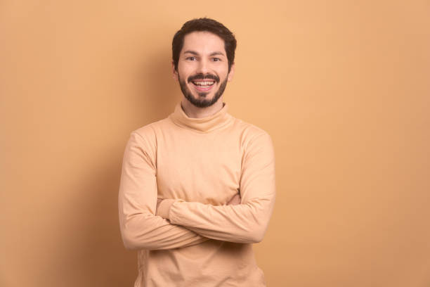 istock portrait of man smiling and looking at camera in beige studio 1889574116