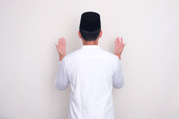 istock Back view of moslem man doing praying gesture 1889600888