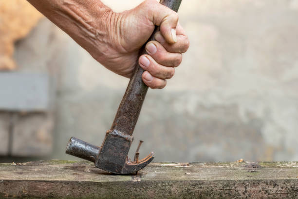 istock Nail puller is removing the nail from the wooden board. Small carpentry work in the workshop. Home renovation. 1889615292