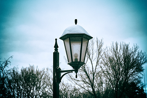 Lantern in the park in winter. Vintage style photo