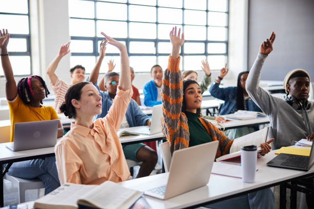 istock College students raising their hands to ask questions during a class 1889685096