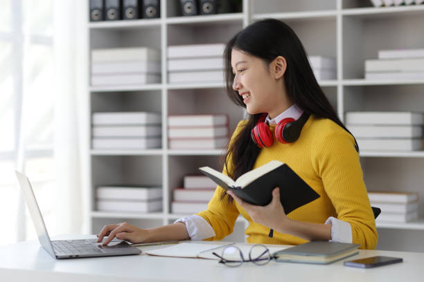 istock Beautiful Asian female student reading academic books in university library. 1889686138