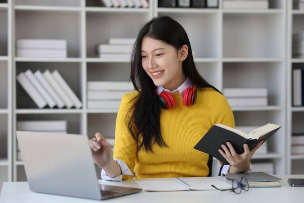 istock Beautiful Asian female student reading academic books in university library. 1889686146