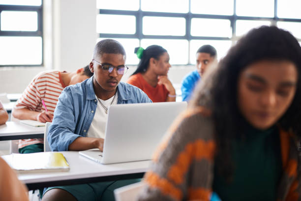 istock Young male college student using a laptop during a class at school 1889687270