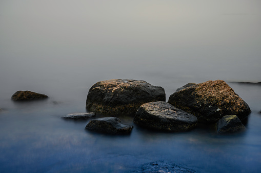 Foggy Beach Winter Seascape with Glacial Stones, misty islands and horizon at Rocky Neck Beach State Park of Long Island Sound in Niantic, East Lyme, Connecticut, United States