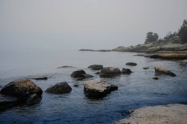 istock Foggy Seascape with Glacial Stones, misty islands, and hilly cliffs 1889698571