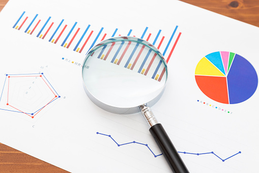 Graph and magnifying glass.