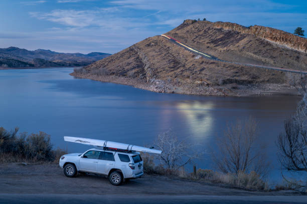 toyota 4runner suv com uma concha de remo, literace 1x por liteboat em racks de teto em uma margem de horsetooth reservoir - cenário crepuscular de outono ou inverno. - 1x - fotografias e filmes do acervo