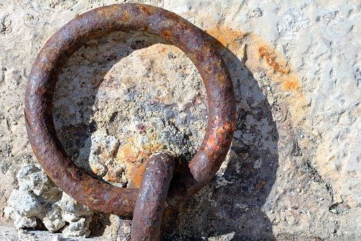 Close up of a mooring ring with a rope. High angle view. Concrete background. Cassis, Boûches du-Rhône, France.