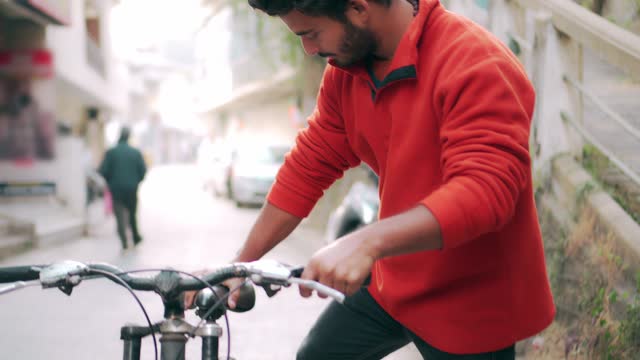 Man uses a bicycle and his phone within a 15-minute city.