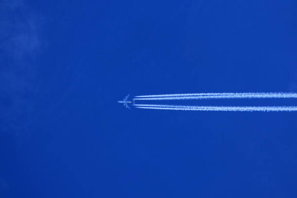istock Airplane in the blue sky with contrail 1889794315