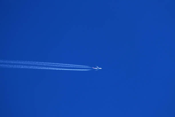 istock Airplane in the blue sky with contrail 1889794319