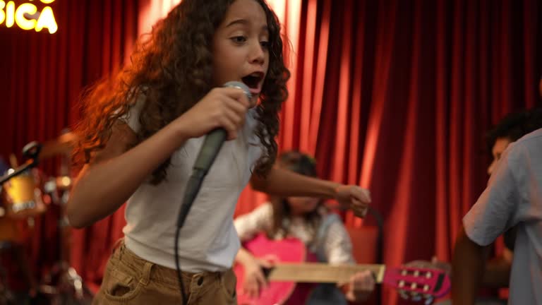 Child friends dancing and singing on rehearsal at music school