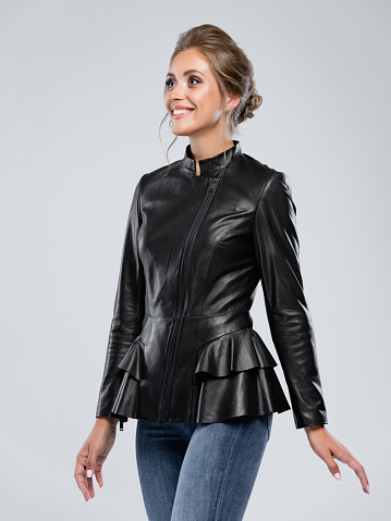 Professional model is posing for lookbook in the studio on white background. Woman wear Leather Jacket and jeans.