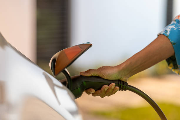 istock Hand plugging charger into electric car 1889872026