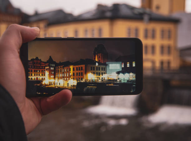 istock Cropped hand holding a mobile phone against building 1889908244