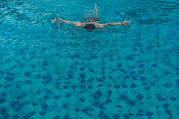 istock Top view of man swimming front crawl in blue water 1889914064