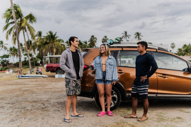 istock Surfer friends talking when they arrive with car on the beach 1889938695