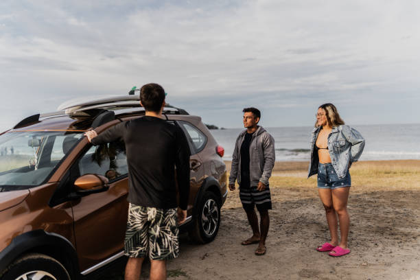istock Surfer friends talking when they arrive with car on the beach 1889939216
