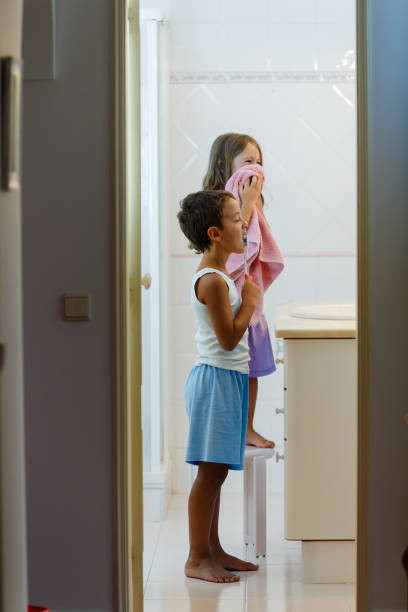 istock Side view of children brushing teeth in the bathroom 1889954412