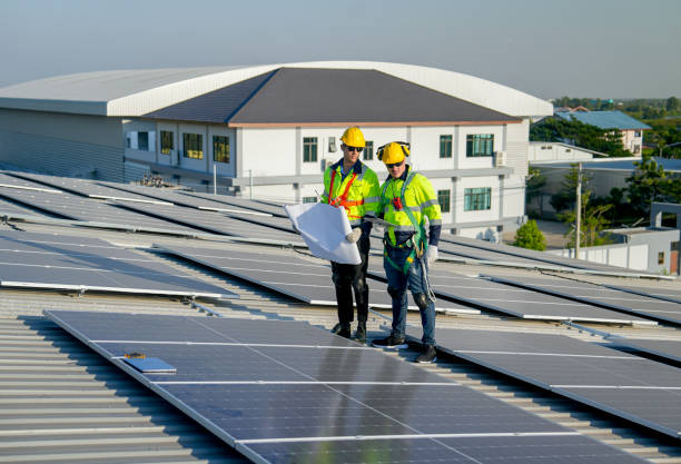 istock Caucasian technician workers stand with hold construction plan and discuss to co-worker about maintenance solar cell panels on rooftop of factory or the building. Green and sustainable energy concept. 1889973205