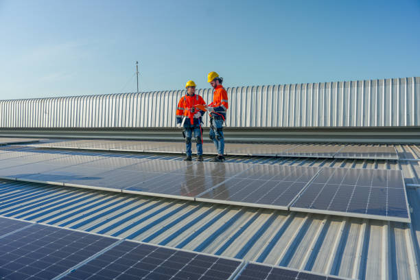 istock Two Caucasian technician workers stand on rooftop and discuss about the maintenance solar cell panels on rooftop of factory or the building. Green and sustainable energy concept. 1889973209