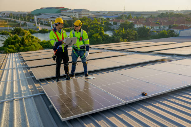 istock Two Caucasian technician workers stand on rooftop and discuss about the maintenance solar cell panels on rooftop of factory or the building. Green and sustainable energy concept. 1889974271