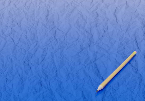 A crumpled piece of white paper lies next to a wooden pencil on a clean surface. This setup highlights the creative process, emphasizing the importance of brainstorming and drafting ideas.