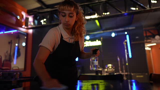 Waitress young woman cleaning a table on a pub