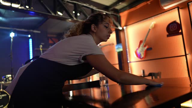 Waitress young woman cleaning a table on a pub