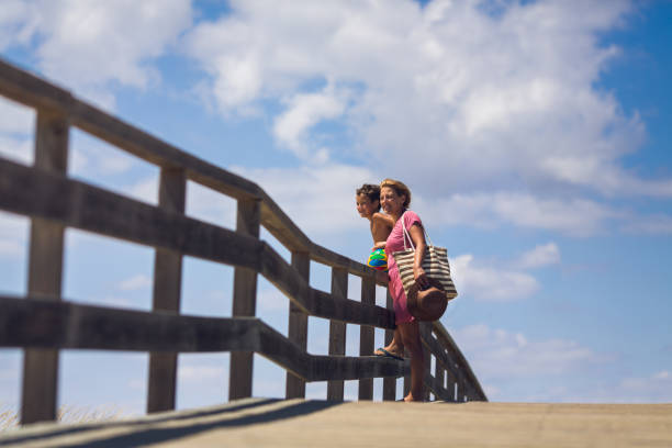 madre e hijo paseando juntos por la playa en el algarve, portugal - beach family boardwalk footpath fotografías e imágenes de stock