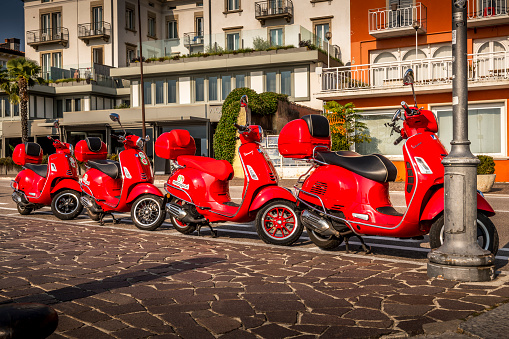Torbole, Italy - October, 02. 2023: some red vespas parking in row in Torbole in Italy