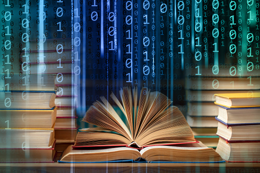 Close-up of books on a binary code abstract background with glowing light rays. Can illustrate the concept of e-books, online reading, e-learning, online education etc.
