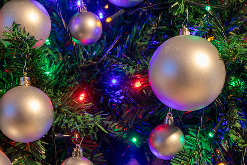 christmas tree decorations and old lamp garland for illumination on defocused blue background