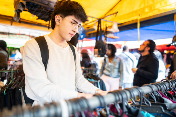 istock Young man looking for clothes on the street market 1890182012