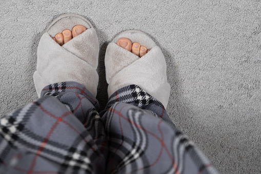 Closeup of unisex slip on shoes on a wood floor.