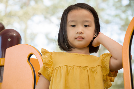 One elementary age child at playground.  Asian.