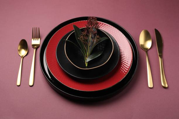 istock Stylish table setting with cutlery and floral decor on pink background 1890331981