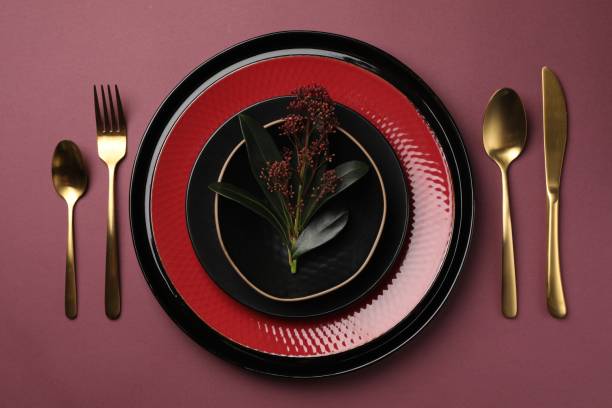 istock Stylish table setting with cutlery and floral decor on pink background, flat lay 1890331983