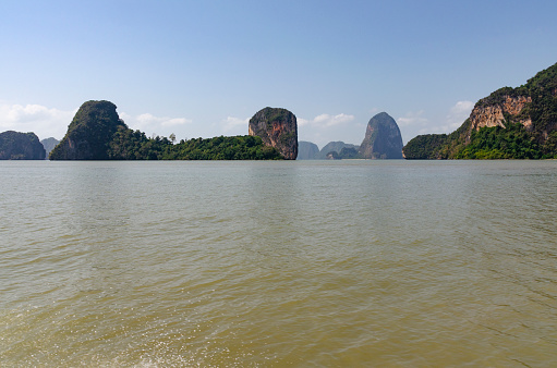A breathtaking image of Ao Phang Nga National Park, capturing the dramatic limestone cliffs and emerald-green waters. This iconic landscape, dotted with lush islands and tranquil coves, epitomizes the serene beauty and geological wonder of this renowned area in Thailand.