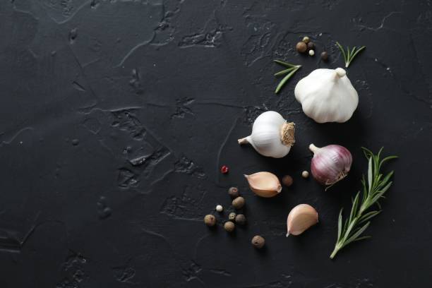 istock Fresh raw garlic and spices on black table, flat lay. Space for text 1890346955