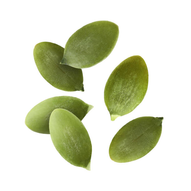 istock Peeled pumpkin seeds falling on white background 1890355037